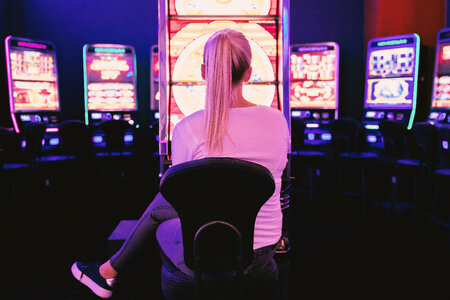 1 Young woman playing at slot machine in casino photo