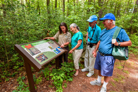 FWS Visitor services staffer shows interpretive panel to visitors