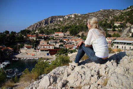 Girl sitting on a rock and looking into the landscape
