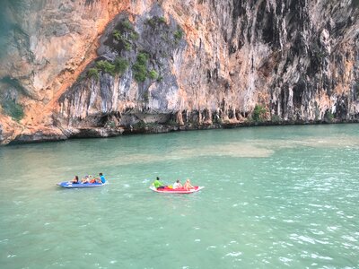 Tourists kayaking through limestone cliffs in Phang-nga Bay photo