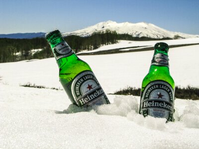 Glass bottles of beer in snow photo