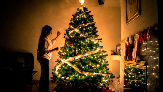 Woman decorating Ornamented Christmas Tree photo