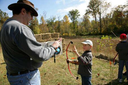 Adult teaching archery to a young boy-2