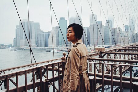 Woman wearing a Trench Coat standing on Brooklyn Bridge, New York photo