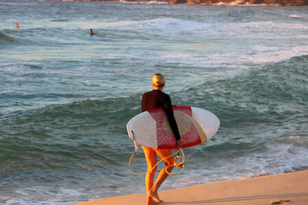 Beautiful young woman surfer girl in bikini with white surfboard photo