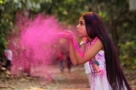 Girl Blowing Pink Powder From Her Hands photo