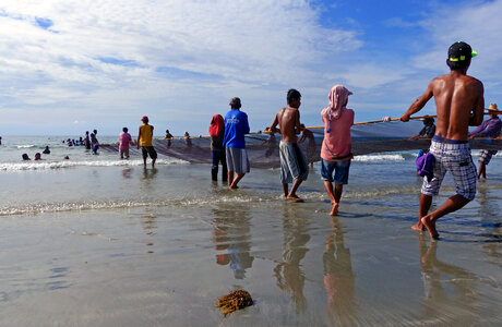 Fisherman on shore pulling up large net