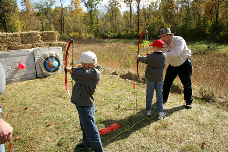 Adult teaching archery to a young boy-2