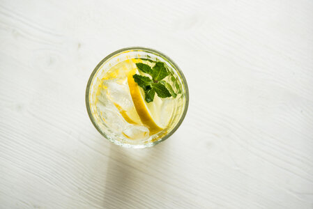 Water with Fresh Lemon, Mint and Ice on Wooden Background photo