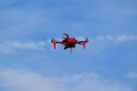 Red Drone Flying in the blue Sky photo