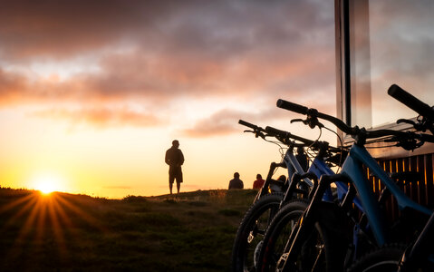 A group of people meet the sunrise at the peak of the mountain