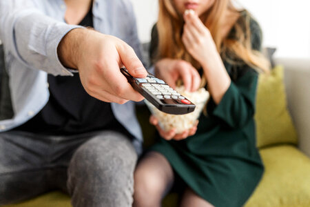 Happy young couple sitting and watching TV at home photo