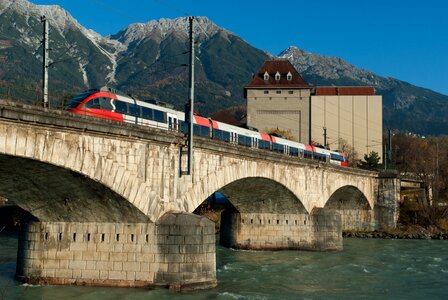 Train crossing ancient bridge photo