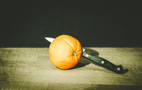 Orange with Knife on Old Cutting Board photo