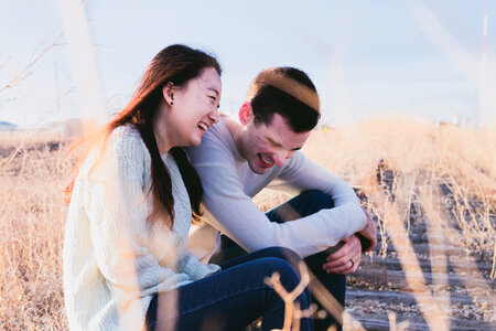 Couple Sitting and Laughing on a Railroad Tracks photo
