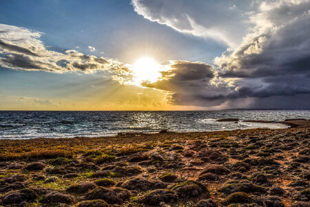 Sunset behind the clouds on the beach photo