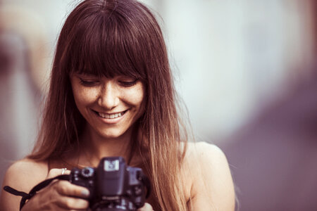 Pretty Woman Is Browse Photos on Her DSLR Camera photo