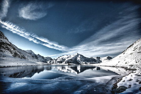 Clouds over the snowy mountains with lake photo