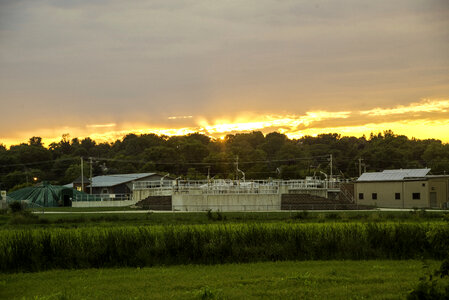 Sun setting above the trees and buildings on the Sugar River State Trail