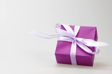 A violet gift with a red ribbon and a bow photo