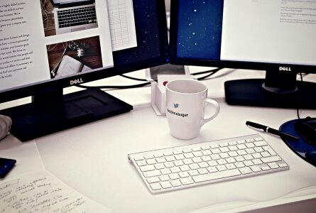 office table with notebook, keyboard, mouse, cup of coffee photo