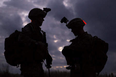 Military silhouettes of soldiers against the backdrop of sunset photo