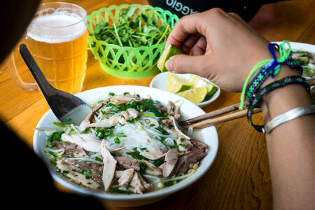 Eating Vietnamese Pho soup with fresh lime photo