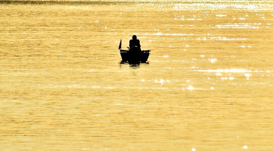Distance fisherman fishing boat photo