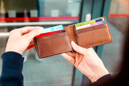 Girls hands holding a wallet with a credit card on the street photo