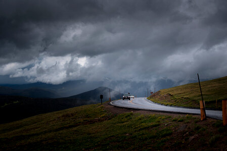 Curved Asphalt Road in a Mountainous Landscape before Storm photo