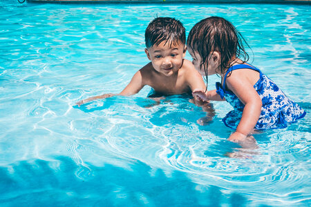 Little Girl and Boy Play in the Swimming Pool photo