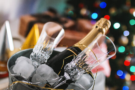 1 Party! Glasses and bottle of Champagne in an ice container. Happy New Year concept. photo