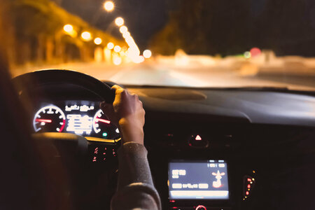 Young woman driving a car at night photo