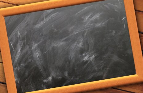 Front view of a blank blackboard over a weathered wooden surface photo