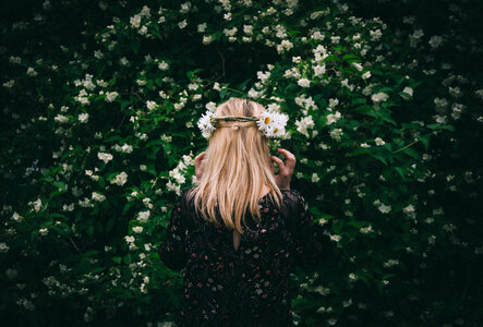 Woman Standing Back by Blooming Jasmine Bush photo