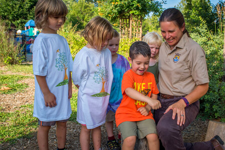 Group of children and fws employee looking at tagged monarch