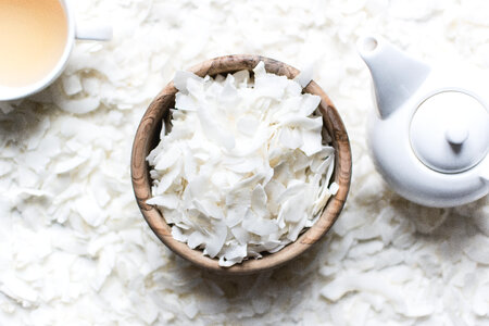 Coconut flakes in a wooden bowl with tea photo