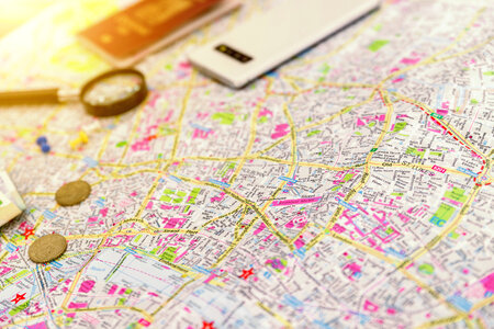 Close-up map. Smartphone, magnifier and passport in background photo