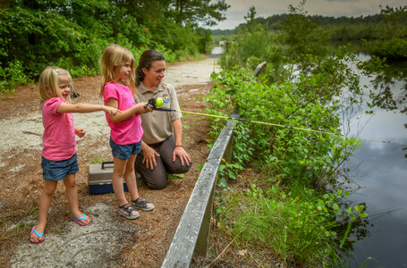 FWS Visitor services staffer shows young girls how to fish
