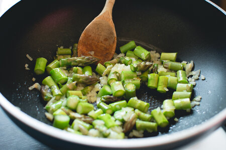 Frying asparagus with onion in a pan photo