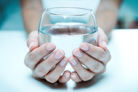 Female hand holding a glass of clean water, close-up. photo