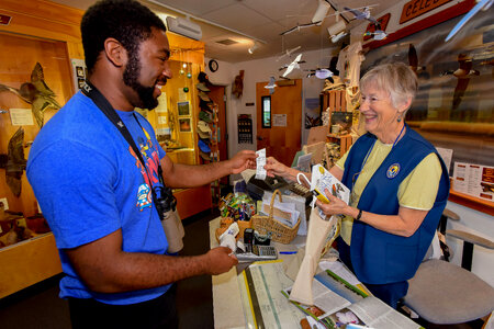 FWS volunteer with visitor in gift shop-1