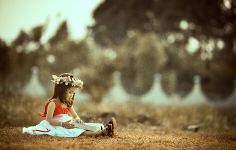 Asian Little Girl Sitting with a Book photo