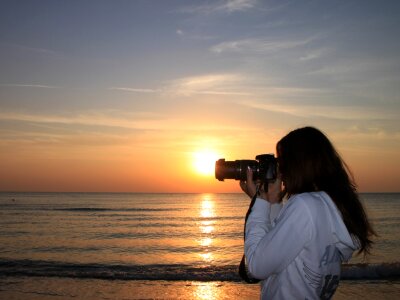 Woman Photographer on the Beach at Sunrise