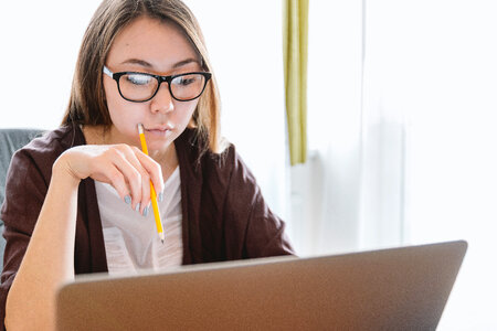 Young woman think and looking on the laptop photo