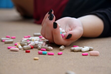 young woman holds some pills photo