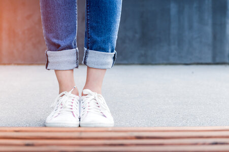 Stylish woman standing in front of concrete wall photo