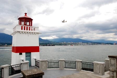Lighthouse with plane flying in Vancouver Port in British Columbia, Canada photo