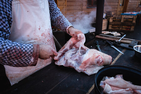 Butcher cutting pork meat photo