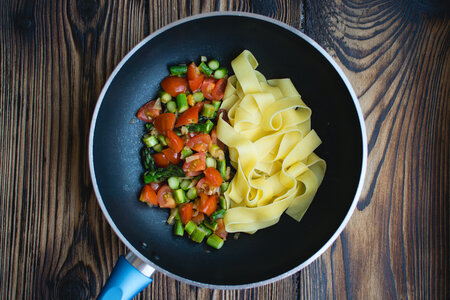 Pasta tagliatelle with asparagus and tomatoes photo